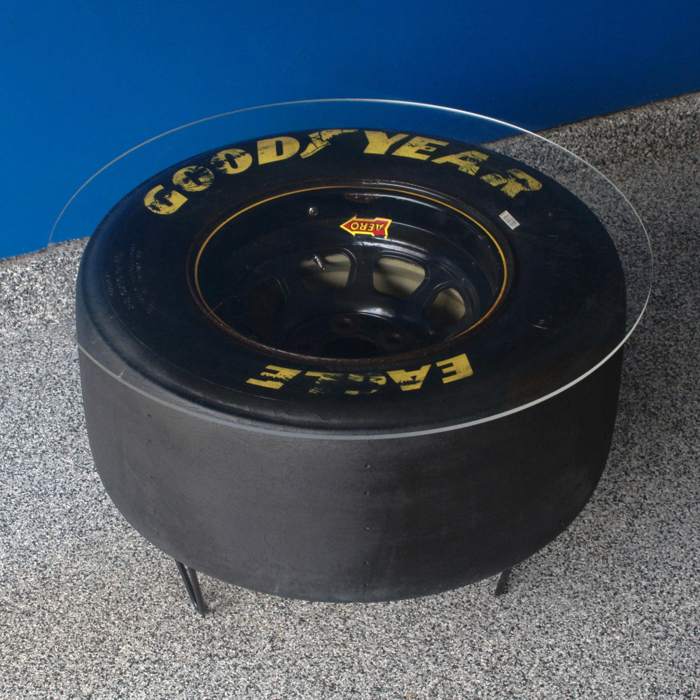 Automotive racing tire table crafted from a retired NASCAR tire, featuring strong materials and bold motorsports-inspired design.