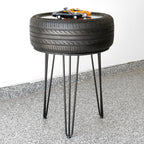 Side table made from a tire with hairpin legs on a concrete floor.