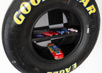 Wall mounted tire shelf with checkered flag backdrop for racing themed decor.