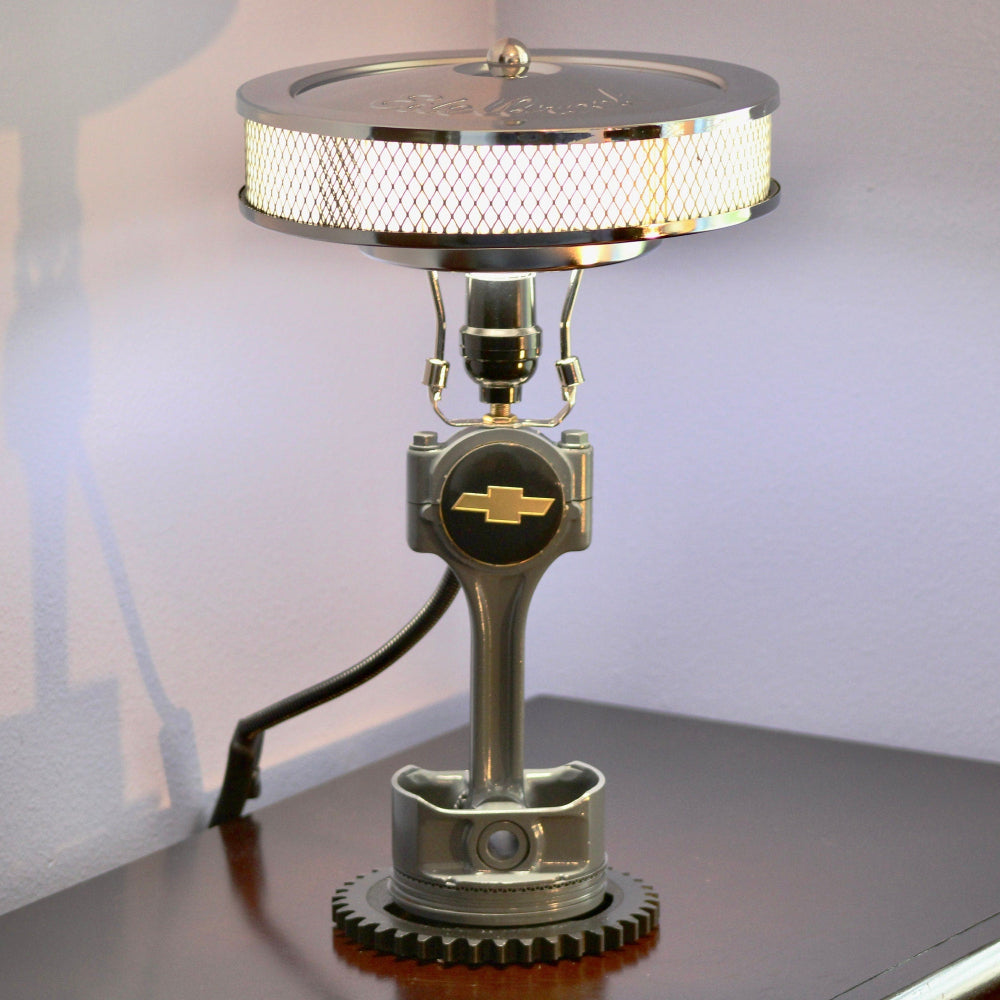 Chevy piston lamp made from real car parts, featuring an upcycled piston and gear with a durable sandblasted metal finish.