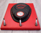 Red tool box with a black cover featuring a Chevrolet logo on a wooden floor.