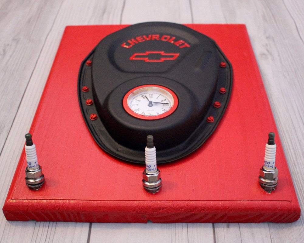 Red tool box with a black cover featuring a Chevrolet logo on a wooden floor.