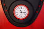 Clock with red frame and black face on a red background