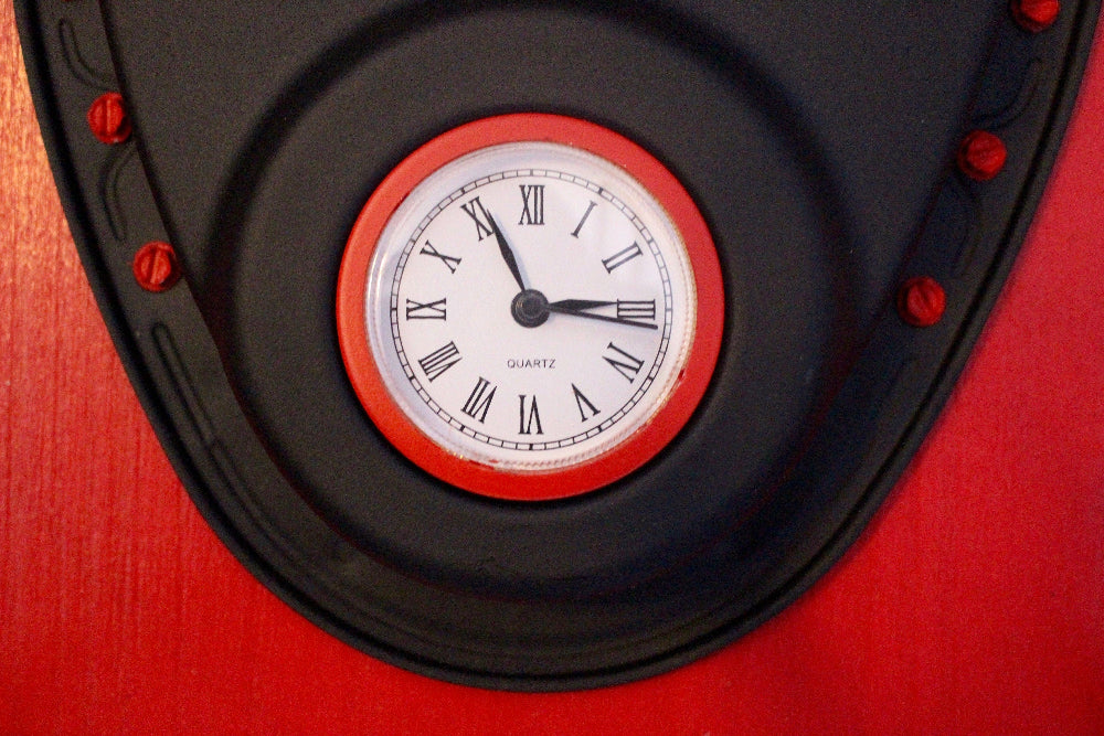 Clock with red frame and black face on a red background