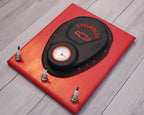 Chevrolet tire pressure monitor on a red stand with small bottles on a wooden floor.