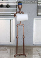 Toilet paper stand built from galvanized pipe with stable freestanding design.