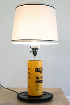 Garage-ready CAT oil filter lamp that delivers bold, worksite inspired automotive and equipment decor.