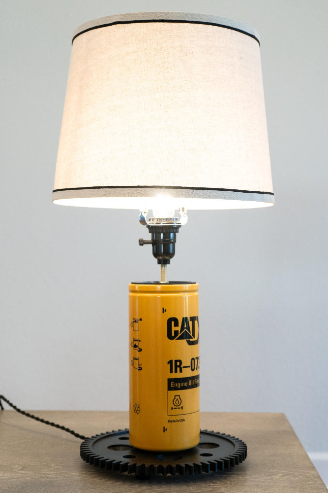 Garage-ready CAT oil filter lamp that delivers bold, worksite inspired automotive and equipment decor.