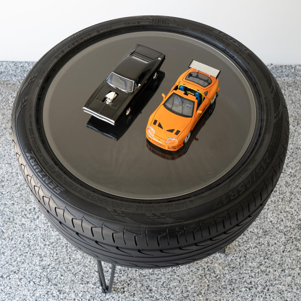 Bar height tire table made from a real recycled tire, designed as a statement table for garages and automotive spaces.
