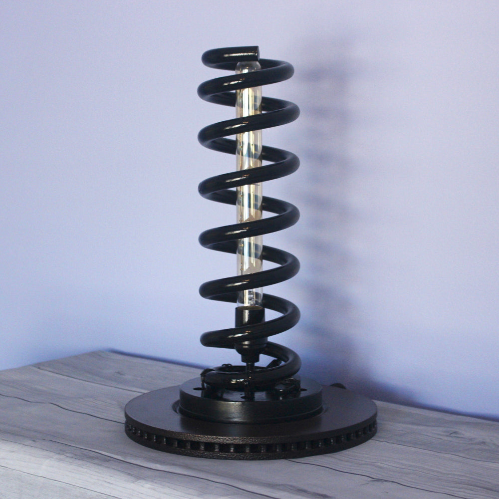 Industrial style spring table lamp that turns mechanical hardware into sculptural, everyday lighting.