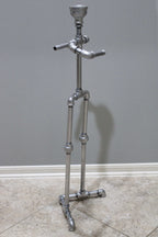Metal toilet paper storage stand with top shelf for small items.
