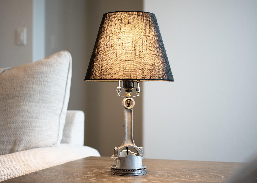 Minimal piston lamp paired with a matte black lampshade, creating a sleek and balanced tabletop lighting piece.