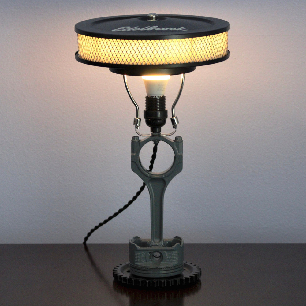 Piston lamp featuring a Chevy logo centerpiece, made from real car parts and designed for automotive themed spaces.