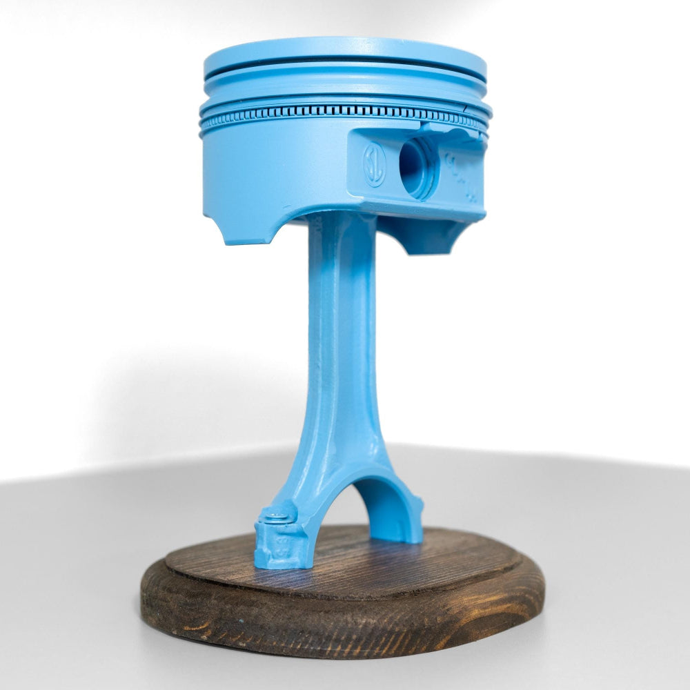 Close up detail of piston trophy showing metal finish and mounted base.