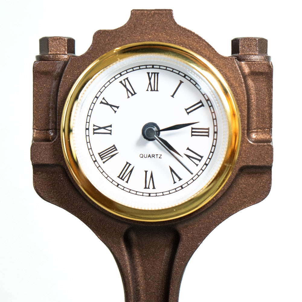 Sandblasted Ford piston clock revealing original stamp and mechanical detail.