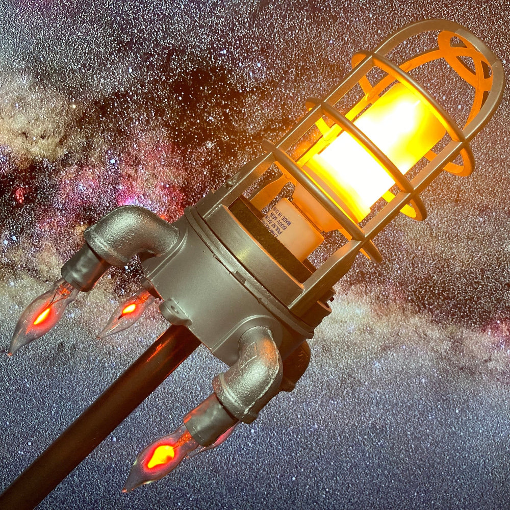 Space rocket lamp with LED flame lighting and shiny silver finish designed for kids rooms and space themed decor.