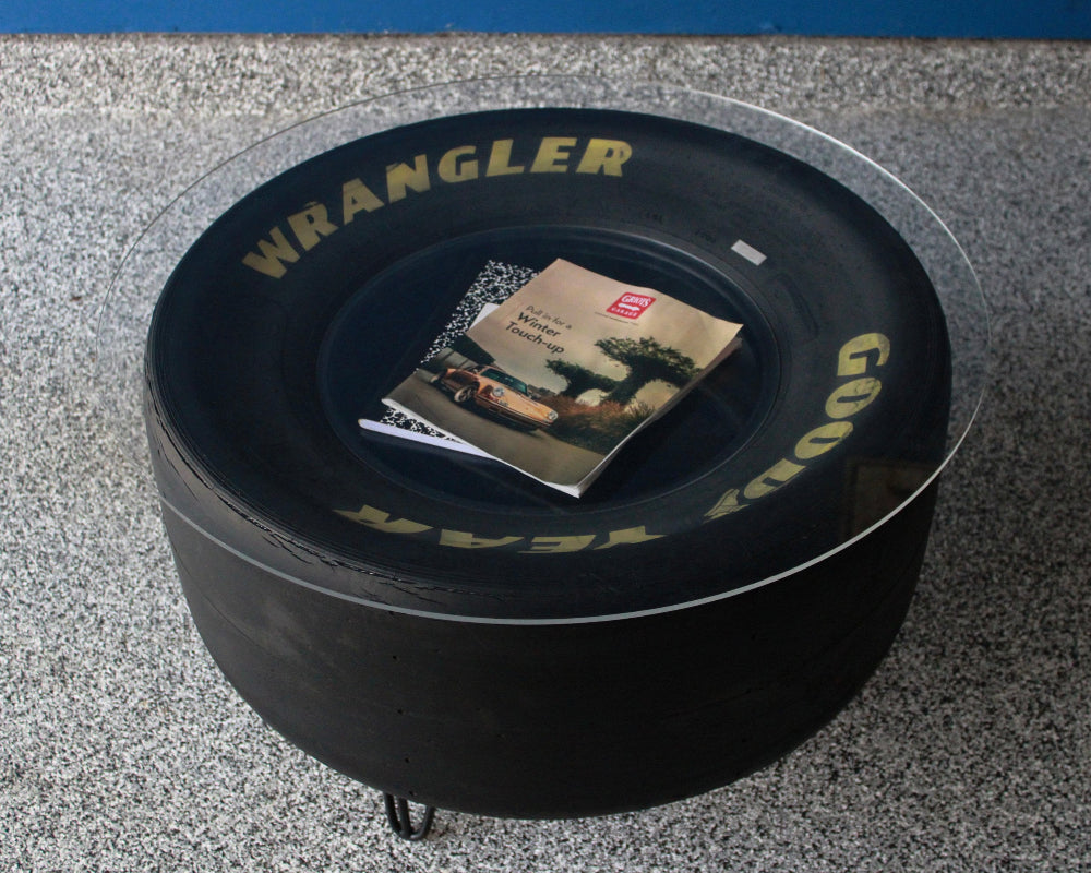 Two tier racing tire coffee table with upper and lower display surfaces.